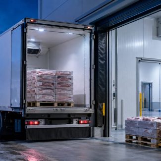 Caminhão refrigerado para transporte de carnes em doca de câmara fria
